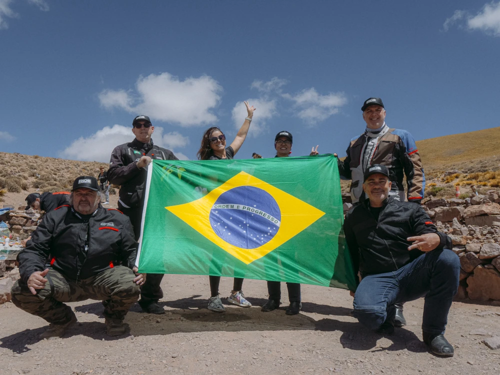 Grupo de motociclistas atravessando paisagem montanhosa dos Andes
